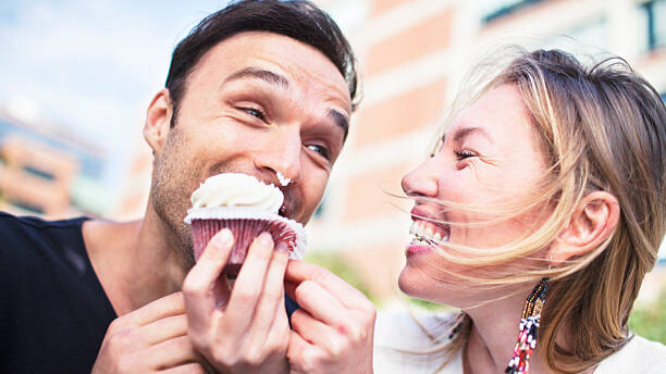 Na slici su muškarac i žena koji uživaju u slatkišima bez griže savesti.