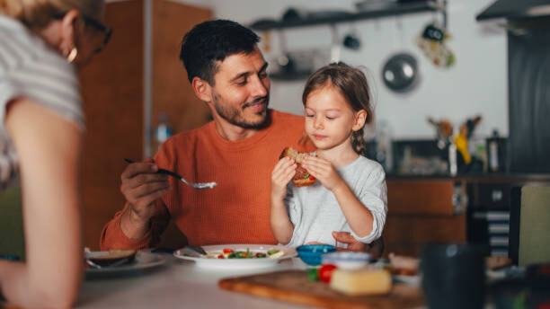 Na slici je prikazana porodica na okupu, za trpezom.