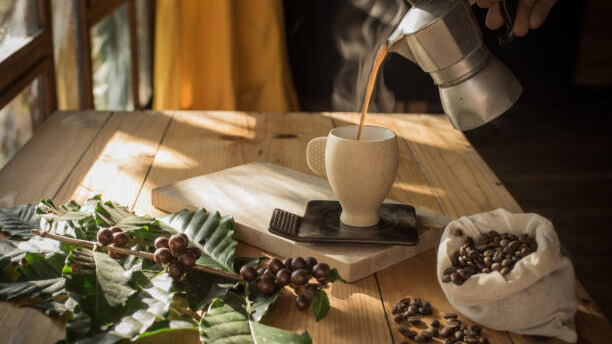 Na slici je prikazano sipanje kafe u šoljicu.