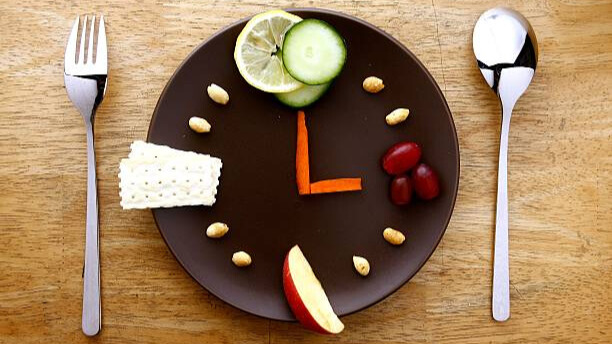 Na slici je prizan raspored hrane na tanjiru u vidu sata - odnosi se na važnost pravilnog rasporeda obroka tokom dana.