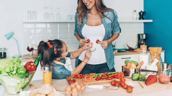 Na slici su prikazane majka i ćerka koje zajedno spremaju hranu u kuhinji.