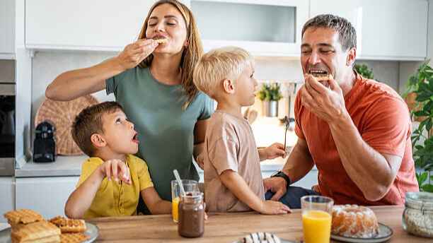 Na slici je prikazana porodica koja jede slatkiše, kao deo balansirane ishrane.