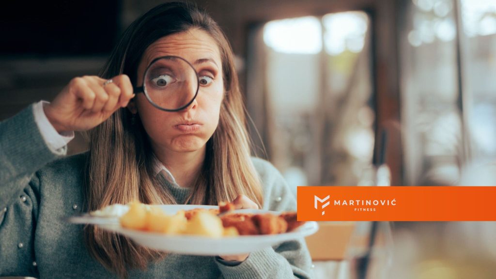 Na slici je prikazana žena sa lupom usmerenom prema hrani (ugljenim hidratima).