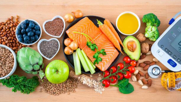 Na slici je prikazana hrana koja snižava krvni pritisak i aparat za merenje pritiska.