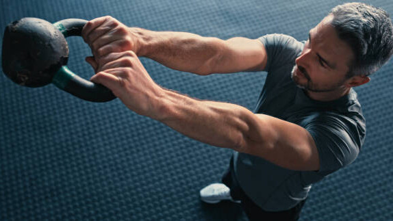 Na slici je prikazan čovek koji praktikuje trening snage, kojim opada nivo kortizola.