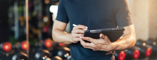 Na slici je prikazan trener koji beleži savete za svoje klijente.