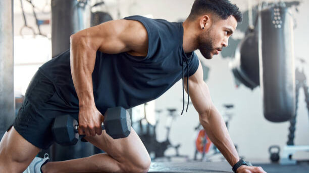 Na slici je muškarac koji izvodi vežbu "jednoručno veslanje" sa bučicom.