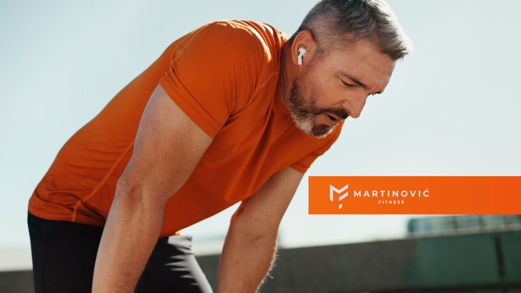 Na slici je čovek koji pravi pauzu tokom treninga, da predahne.