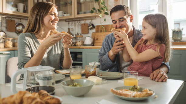 Na slici je porodica koja ruča na okupu.