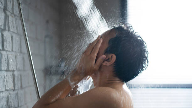 Na slici je čovek koji se tušira.