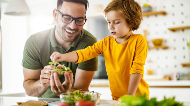 Na slici su prikazani otac i sin kako pripremaju doručak.
