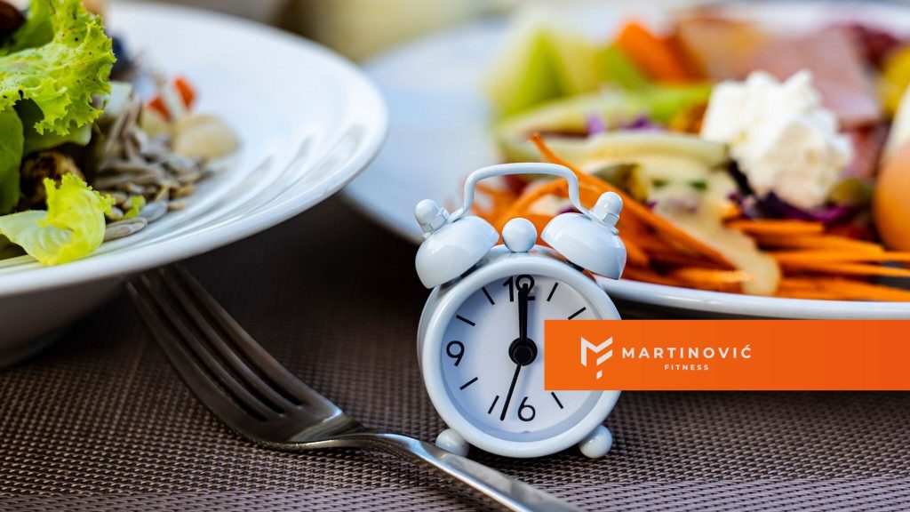 Na slici je prikazan sat uz servirane obroke, kao asocijacija na autofagiju i pridržavanje vremenskog okvira za hranu u toku dana.