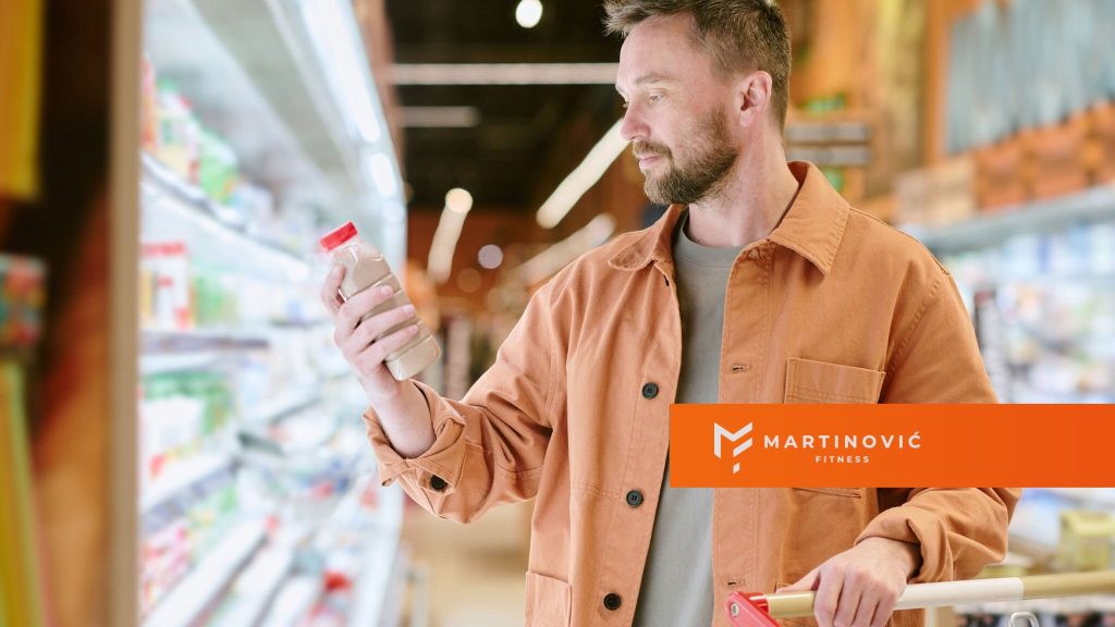 Na slici je muškarac koji proverava deklaraciju da bi otkrio ima li proizvod skrivene šećere.