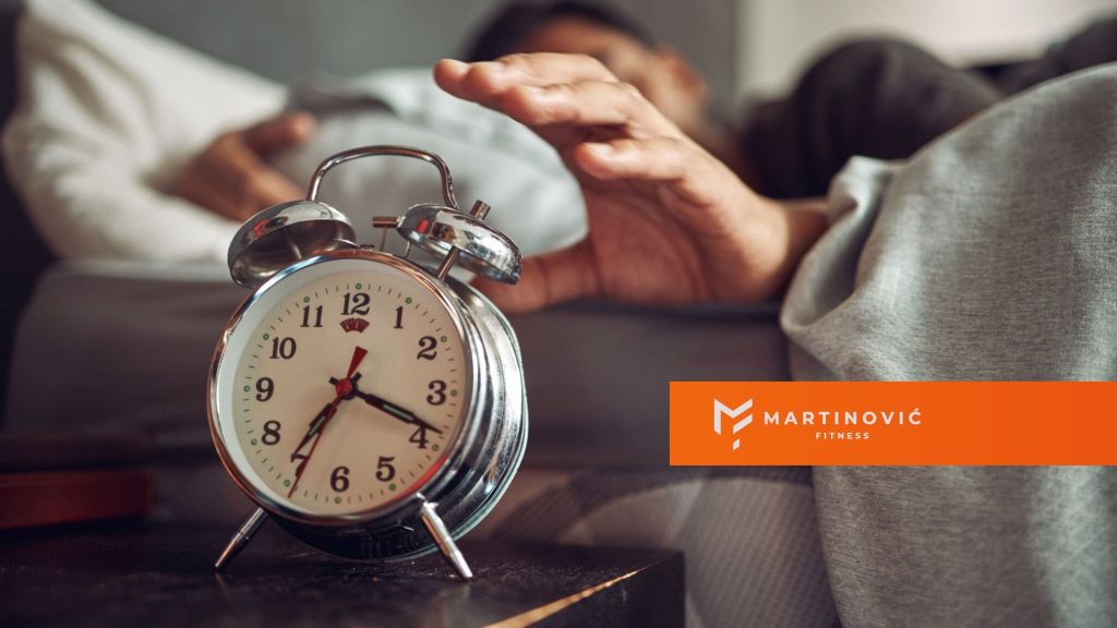 Na slici je čovek koji prekida alarm za buđenje nakon kvalitetnog sna.